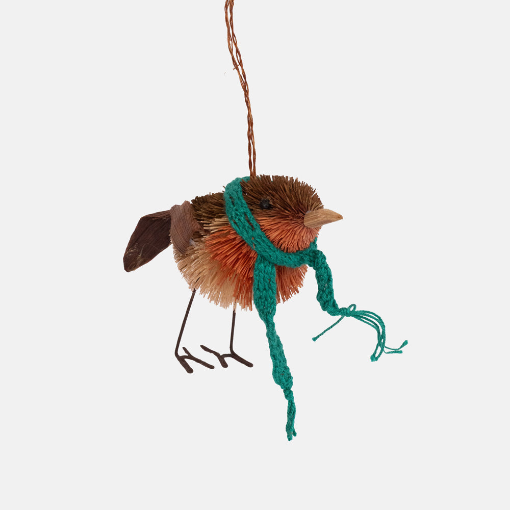 Brown and orange bristle robin ornament with wire legs and a long green knitted scarf, hanging from a copper wire