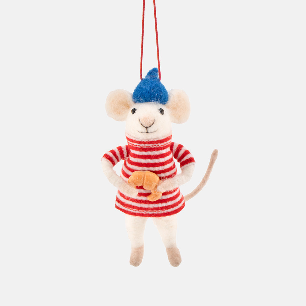 A plush mouse hanging christmas tree decoration with a red and white striped shirt, blue hat, and holding a small orange fish, suspended by a red string against a light gray background.