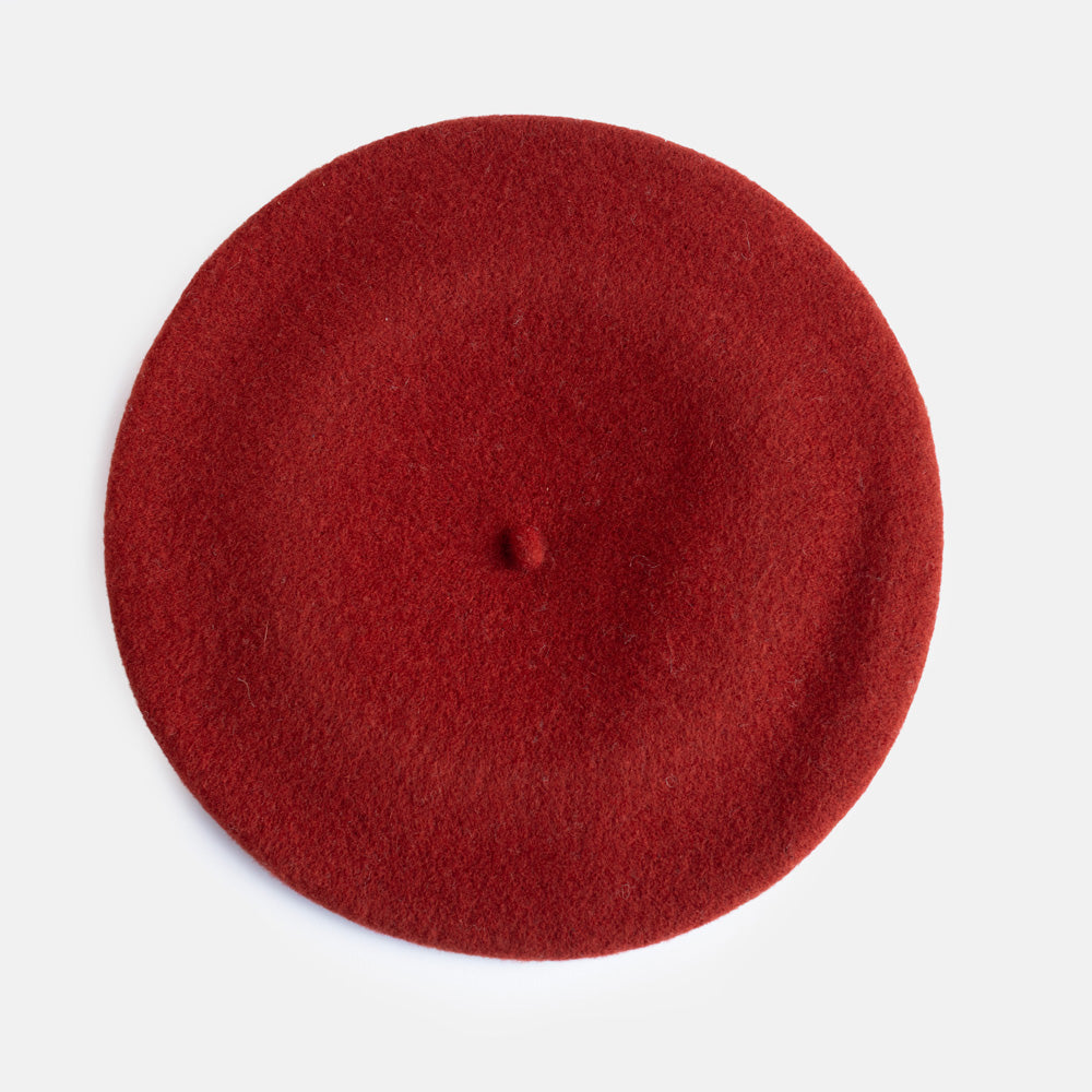 A classic dark orange felt beret hat photographed from a top-down angle on a clean white background.
