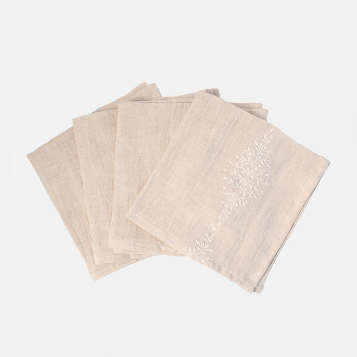 set of 4 off white napkins with floral embroidered design on a white background