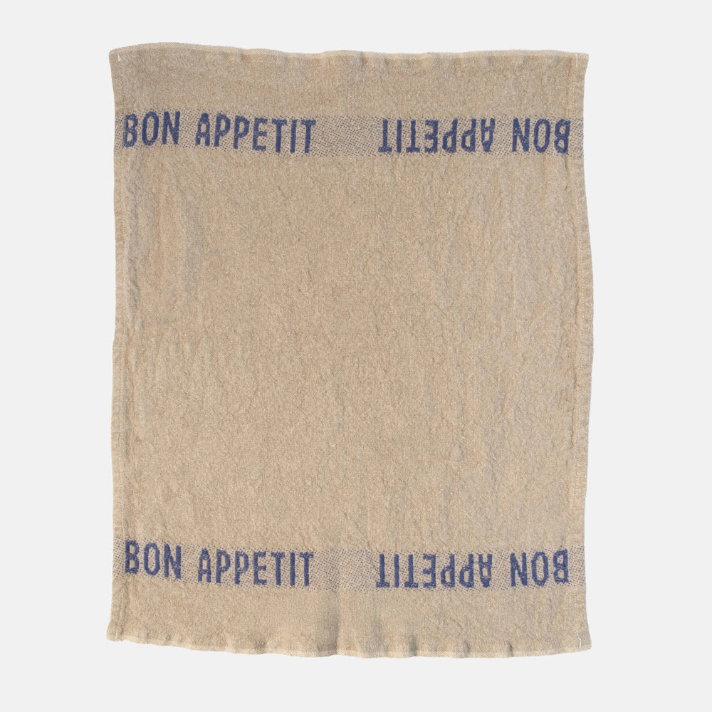 beige napkins with blue 'bon appetit' design on a white background