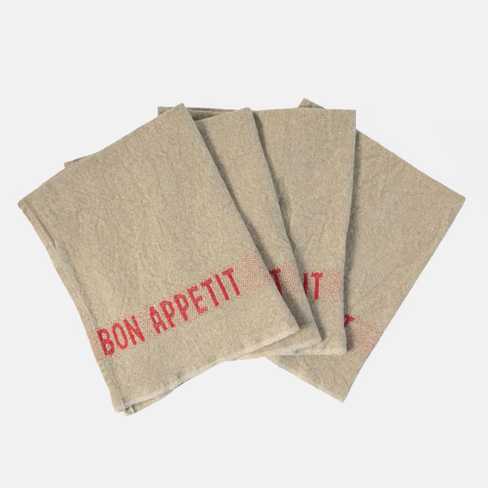 set of 4 beige napkins with red 'bon appetit' design on a white background