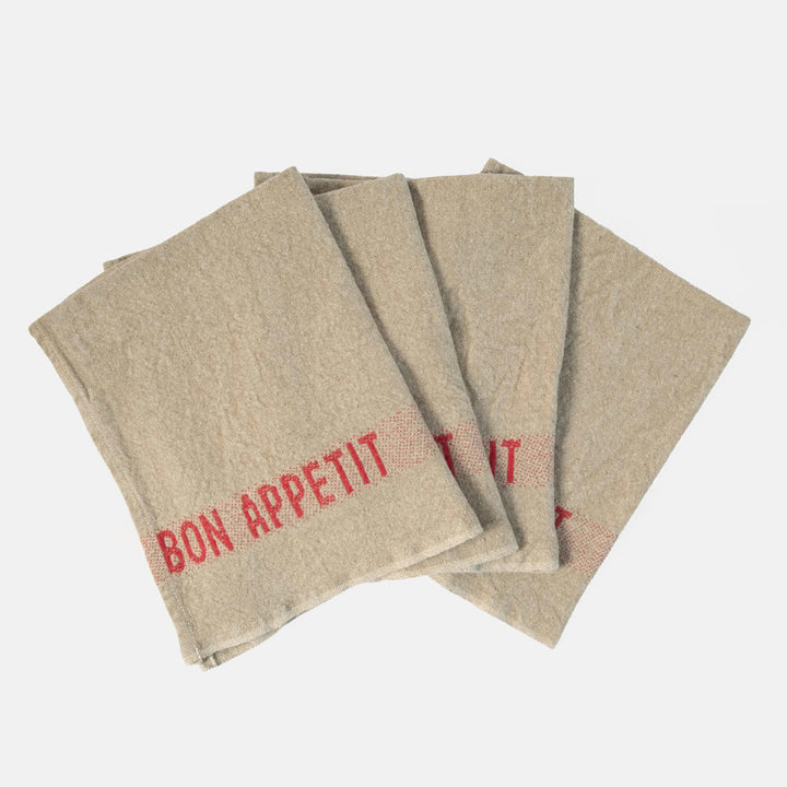 set of 4 beige napkins with red 'bon appetit' design on a white background