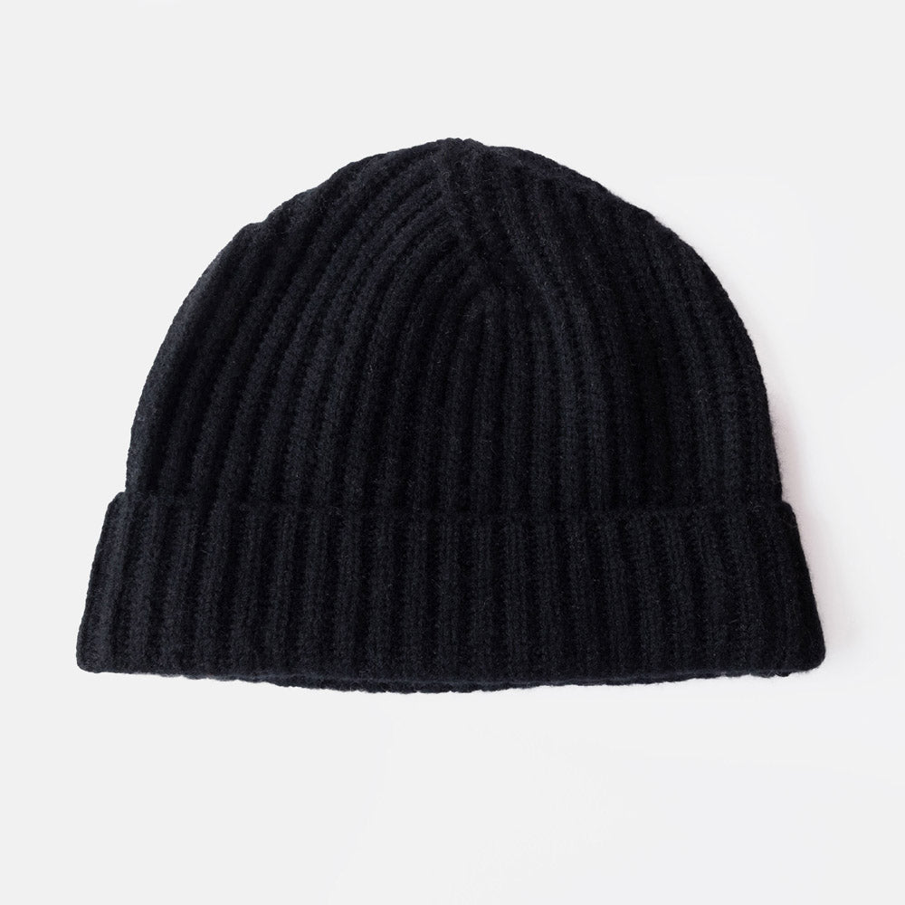 A black ribbed knit beanie hat with a folded cuff, shown against a plain light gray background.
