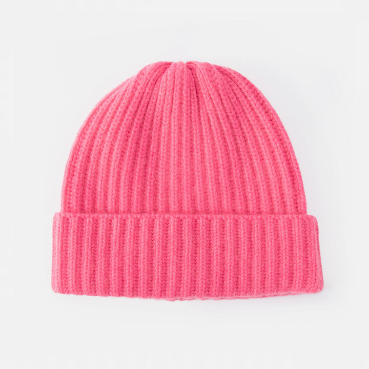 A bright pink ribbed knit beanie hat, shown flat against a clean white background.