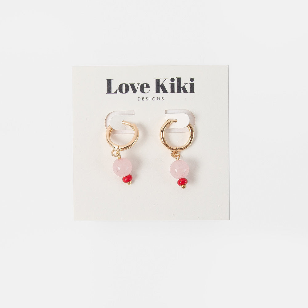 Gold hoop earrings with pink and red beads on a Love Kiki Designs card.