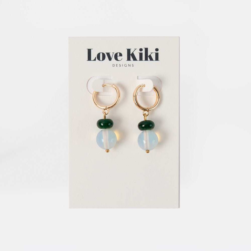 Pair of earrings on a Love Kiki Designs card against a white background