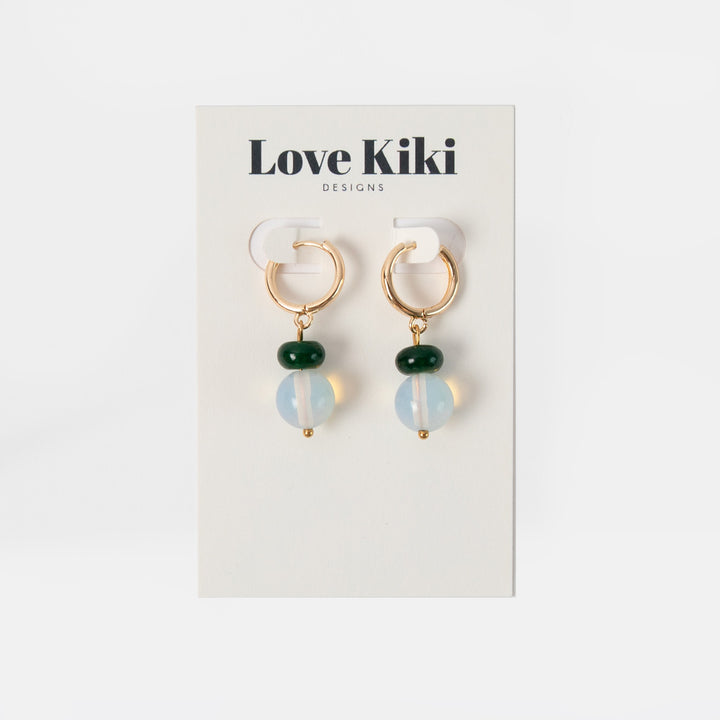 Pair of earrings on a Love Kiki Designs card against a white background