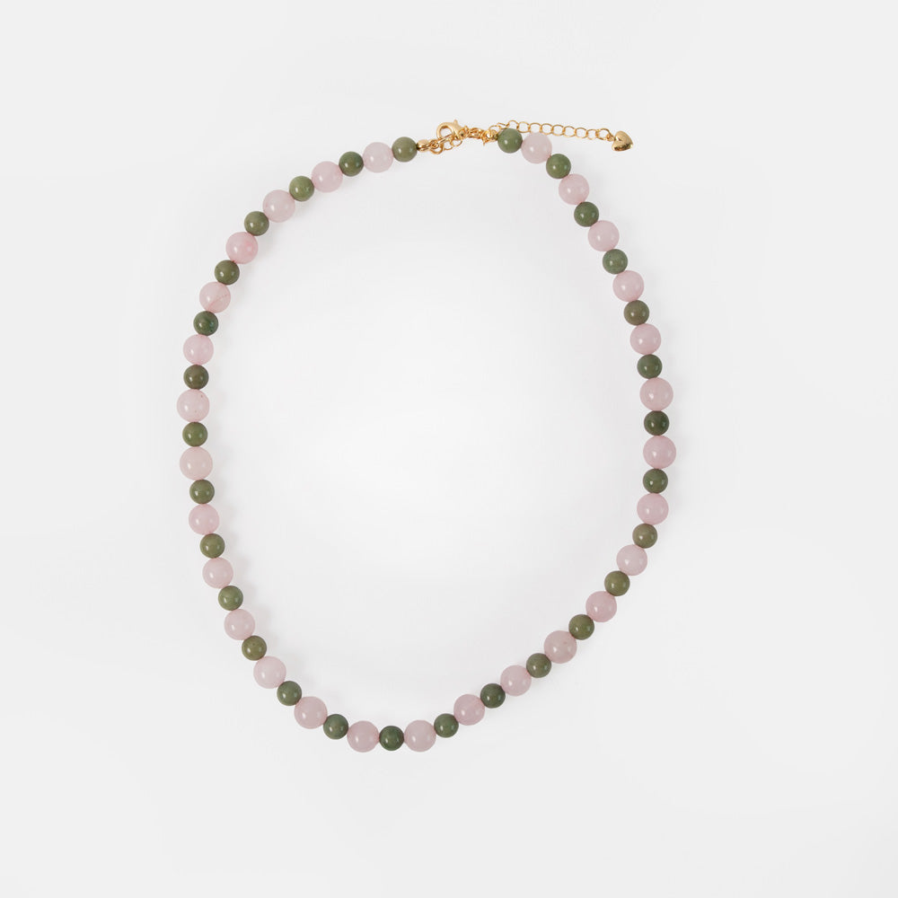 Necklace with green and pink beads on a white background