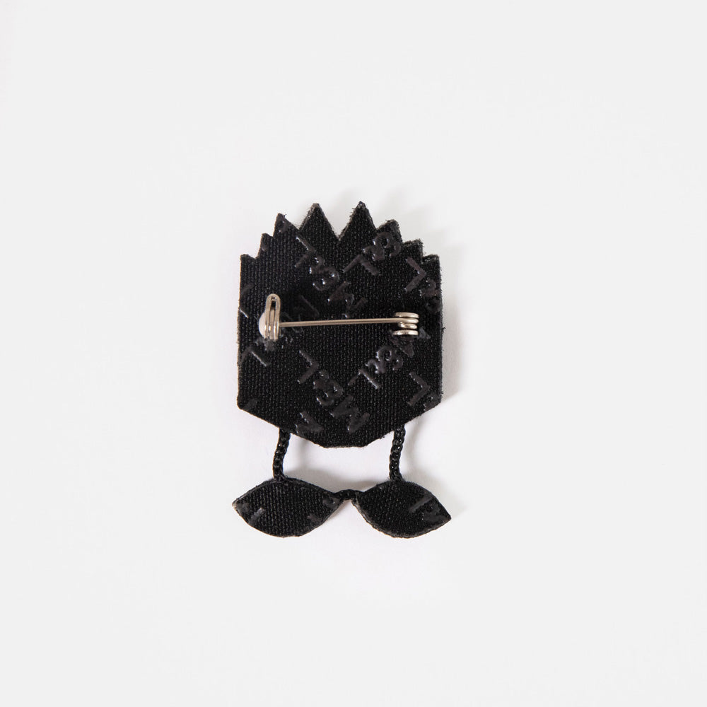 Back of the blue book embroidered brooch showing the black backing and pin fastening.