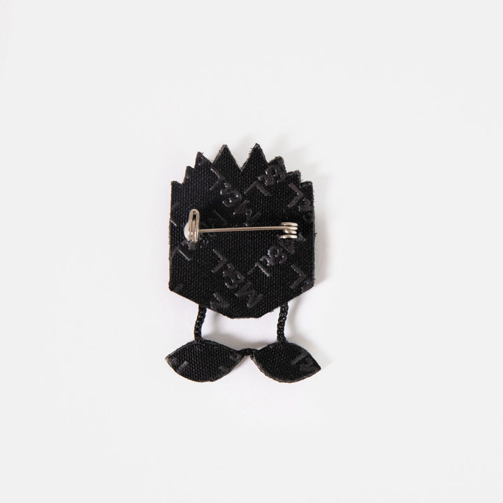 Back of the blue book embroidered brooch showing the black backing and pin fastening.