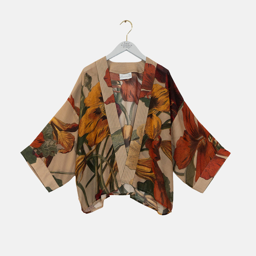A lightweight open-front kimono-style top with wide sleeves, featuring a large-scale floral print in warm tones of orange, red, yellow, and green on a beige base. It is displayed on a white hanger against a light gray background.