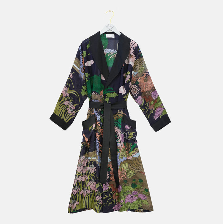 A long-sleeved wrap robe with a black shawl collar and waist tie, featuring a highly detailed, multicolored botanical and animal print, hanging on a white hanger against a light gray background.