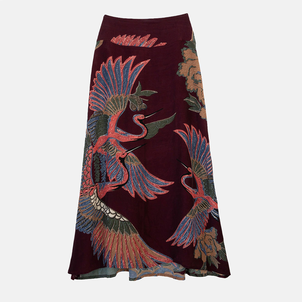 women's a-line maxi skirt featuring a colourful pink, green & blue cranes design on a dark purple base. 