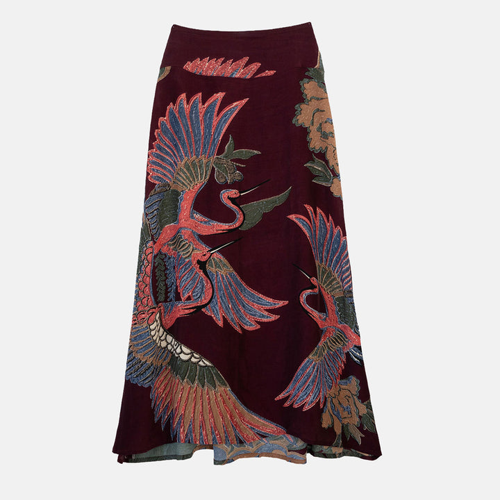 women's a-line maxi skirt featuring a colourful pink, green & blue cranes design on a dark purple base. 