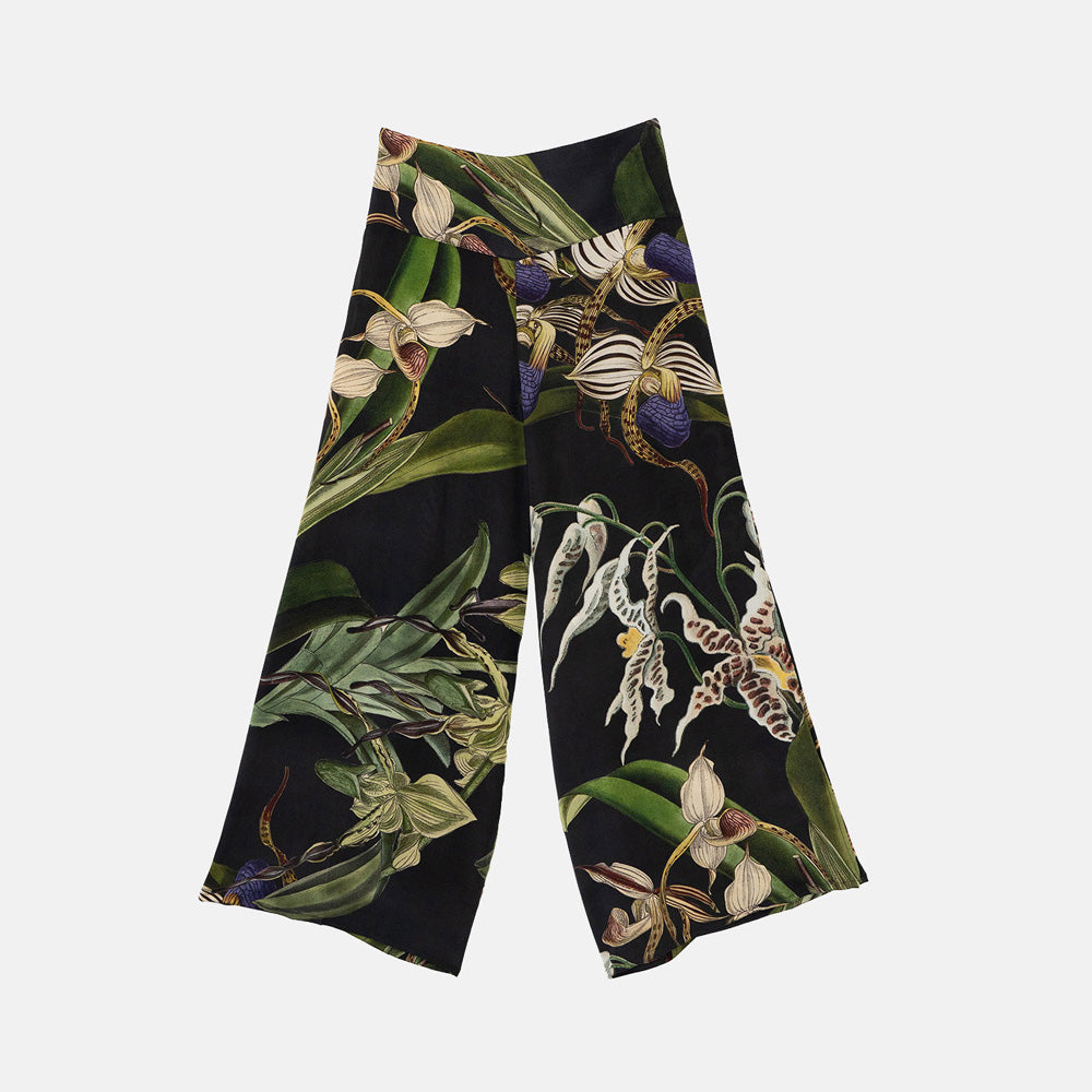 black palazzo pants with a purple, green and white orchid design against a white background