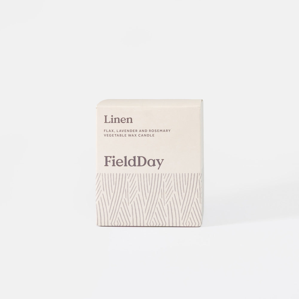 A cream-colored square box for a FieldDay 'Linen' candle, featuring a textured pattern on the lower half and dark gray text, set against a clean white background.
