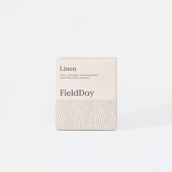 A cream-colored square box for a FieldDay 'Linen' candle, featuring a textured pattern on the lower half and dark gray text, set against a clean white background.
