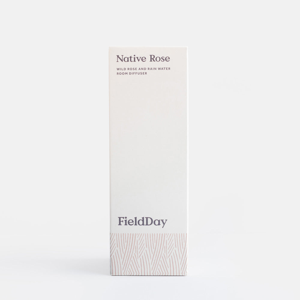 A tall, narrow white box for FieldDay Native Rose room diffuser, featuring dark gray text and a subtle light gray leaf pattern near the bottom, set against a clean white background.