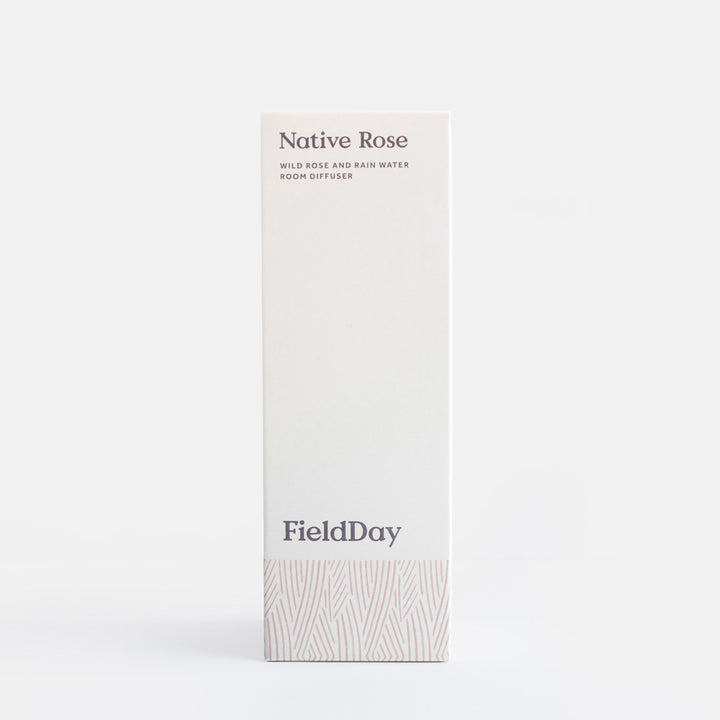 A tall, narrow white box for FieldDay Native Rose room diffuser, featuring dark gray text and a subtle light gray leaf pattern near the bottom, set against a clean white background.