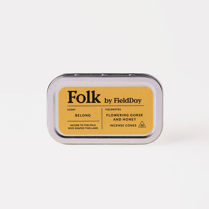 A silver metal tin of Folk by FieldDay incense cones, featuring a mustard yellow label with black text, set against a clean off-white background.