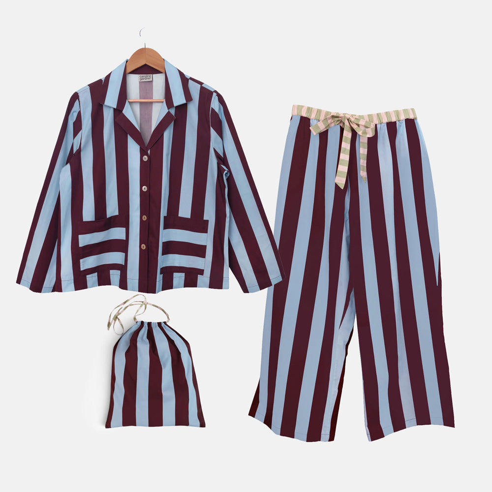 Blue and wine striped long-sleeved pyjama shirt, wide-leg trousers and matching drawstring bag laid out together