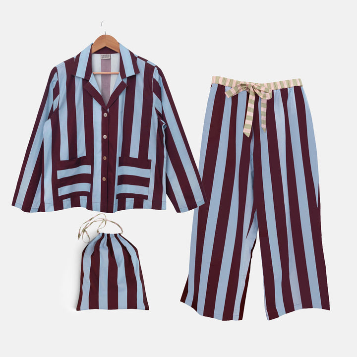 Blue and wine striped long-sleeved pyjama shirt, wide-leg trousers and matching drawstring bag laid out together
