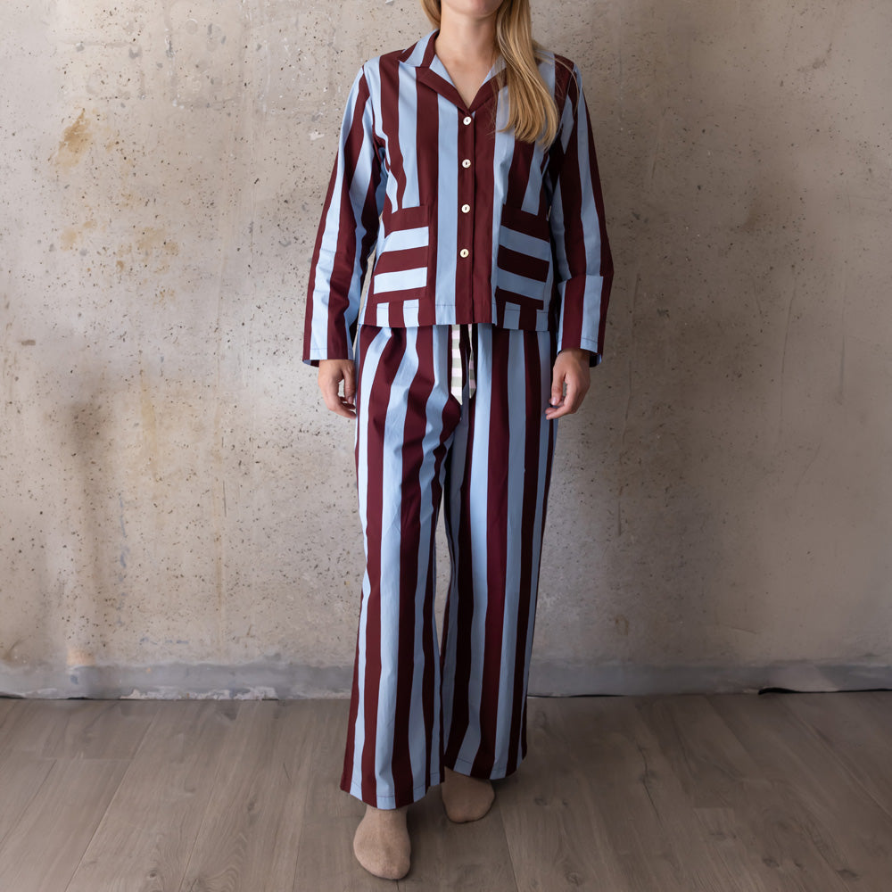 Full-length view of a woman in a blue and wine striped long pyjama set with wide-leg trousers