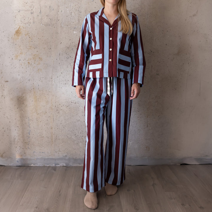 Full-length view of a woman in a blue and wine striped long pyjama set with wide-leg trousers