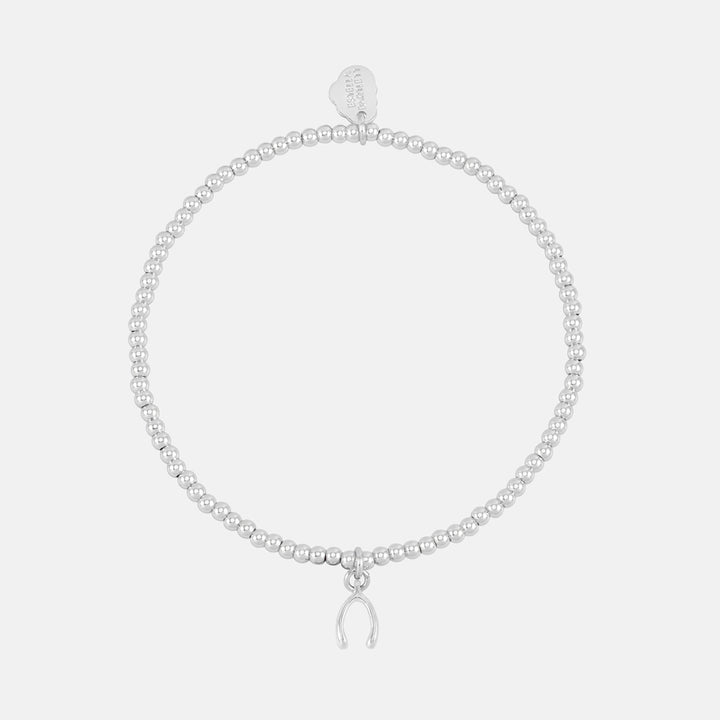 Silver beaded stretch bracelet with a small wishbone charm and heart tag