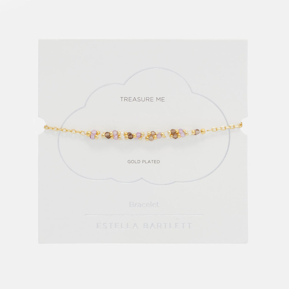 Gold beaded bracelet on a white cloud-shaped gift card