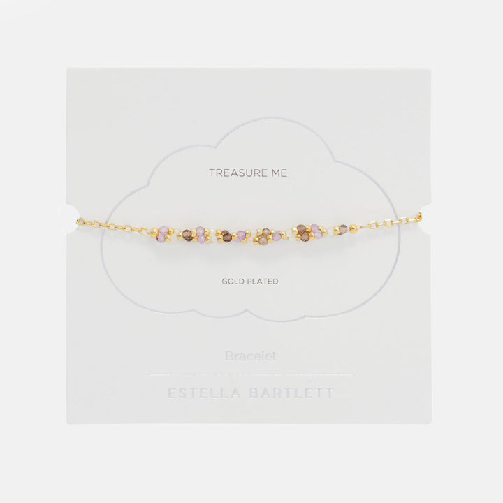 Gold beaded bracelet on a white cloud-shaped gift card