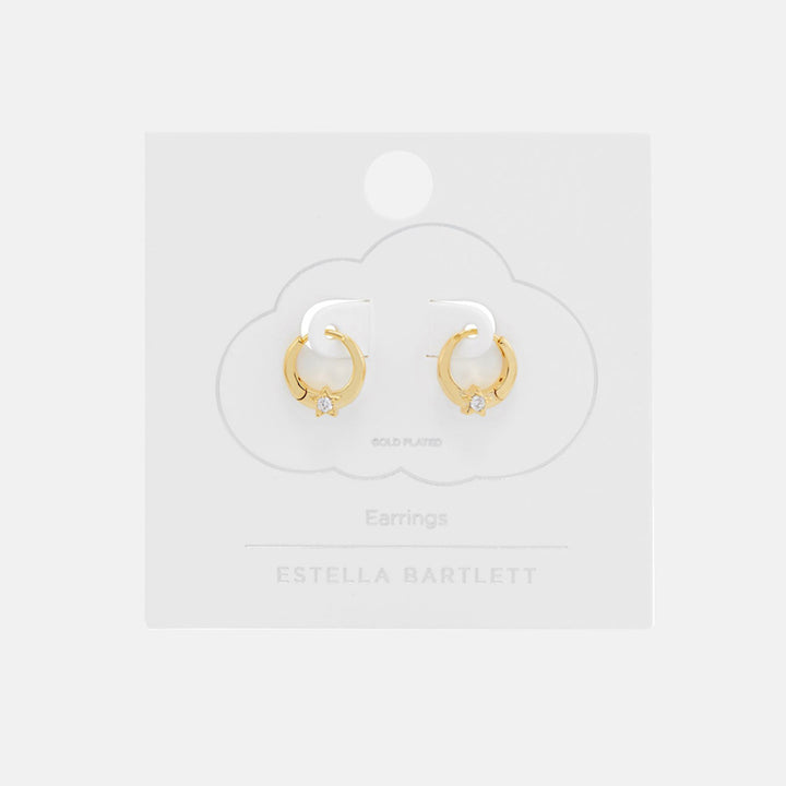 Pair of small gold huggie hoop earrings, each set with a sparkling star, on a white cloud-shaped earring card