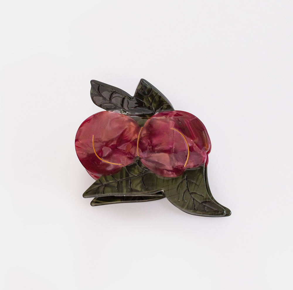 Hair claw shaped like two marbled deep red plums with dark green leaves