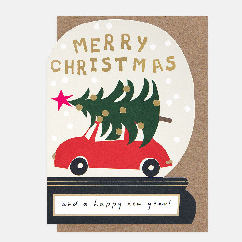 Die cut Christmas card in a snow globe shape with a red car carrying a Christmas tree and 'Merry Christmas and a happy new year!' text.