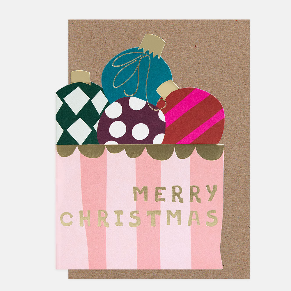 Die cut Christmas card in the shaoe of a box of baubles, with colourful decorations and 'Merry Christmas' text on a brown background