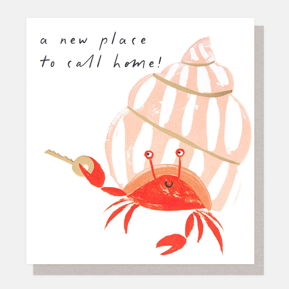 greeting card featuring a smiley hermit crab holding a key and the 'a new place to call home' message
