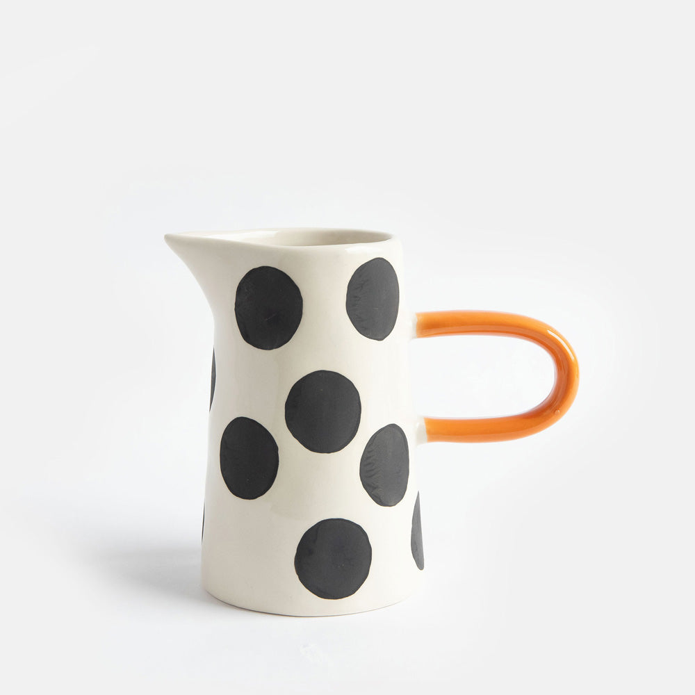 hand painted ceramic jug with big black spots design and orange elongated handle