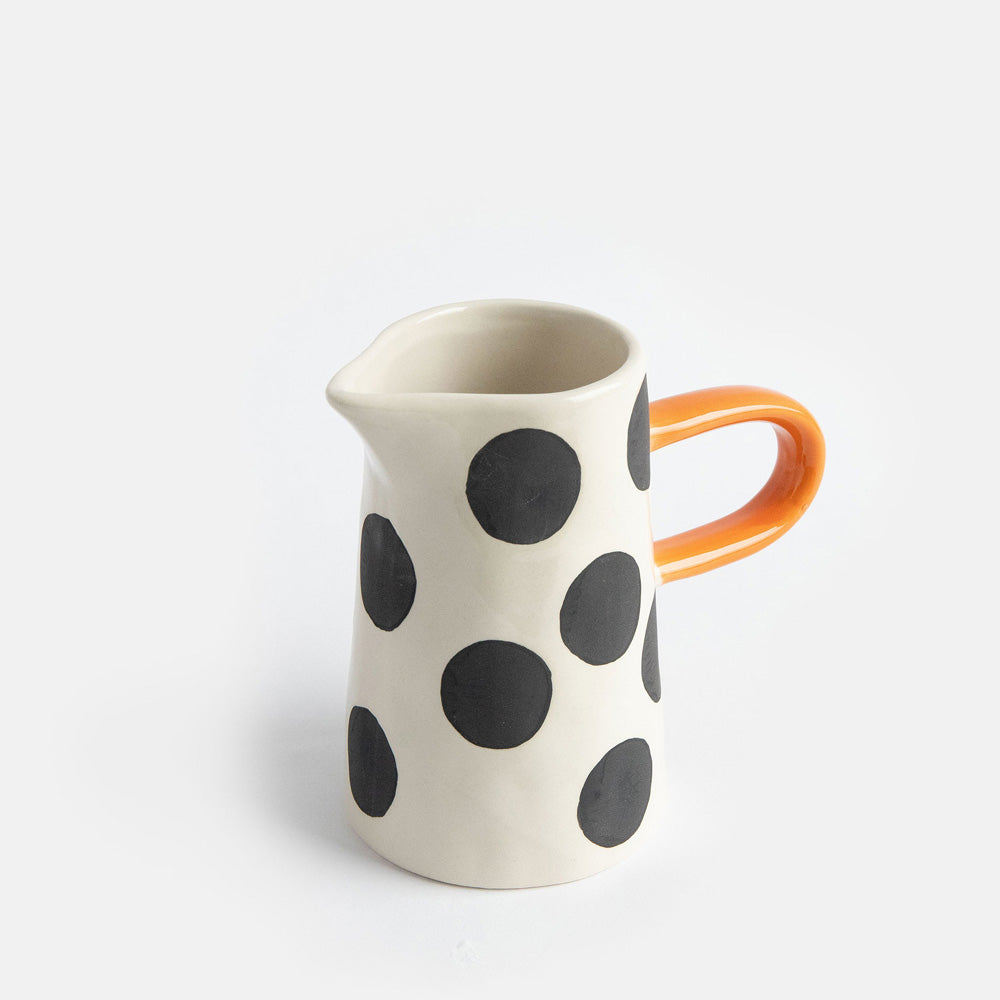 hand painted ceramic jug with big black spots design and orange elongated handle