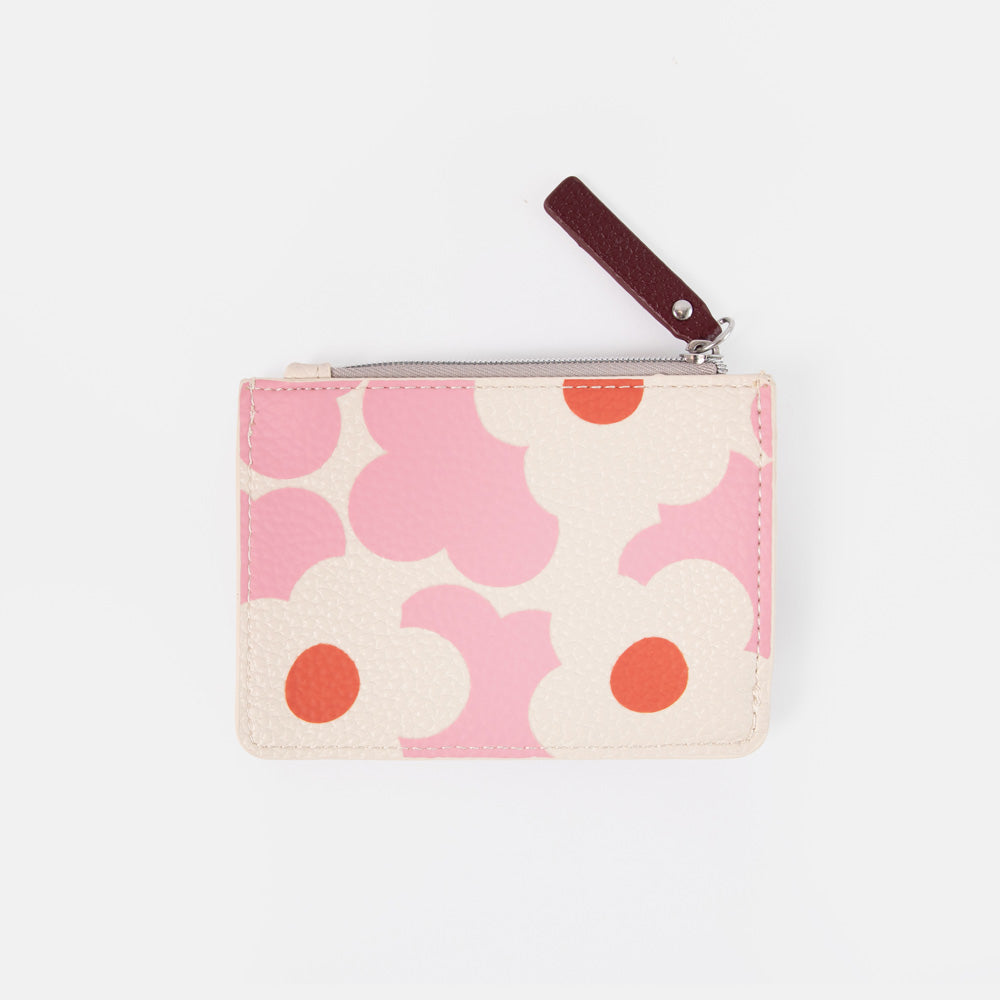A small zippered purse with a pink and cream floral pattern and a dark brown leather pull tab, shown on a light gray background.