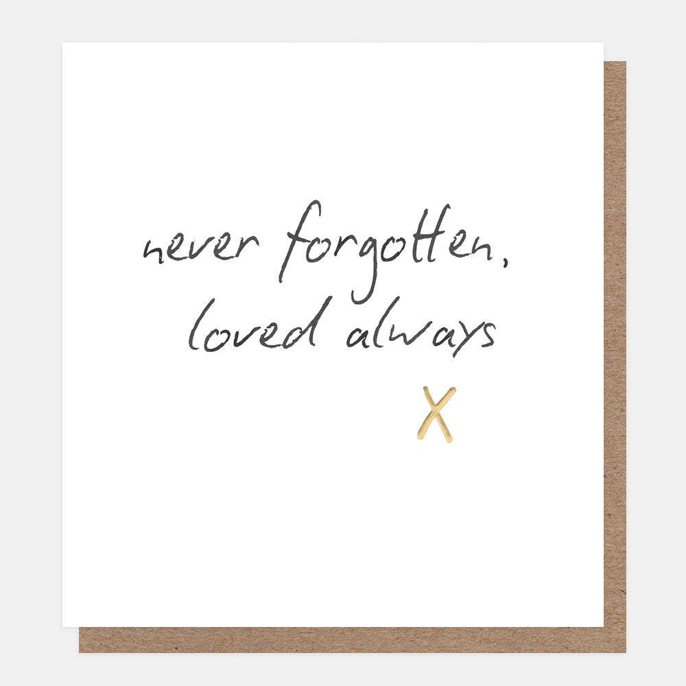 A white greetings card with the words 'never forgotten, loved always' in black handwritten script and a gold foil kiss, shown with a brown kraft envelope behind it.