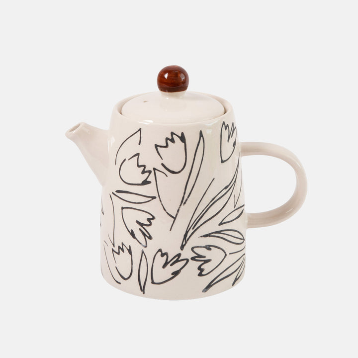 An off-white ceramic teapot decorated with black line-art tulips, featuring a dark brown lid knob, set against a light gray background.