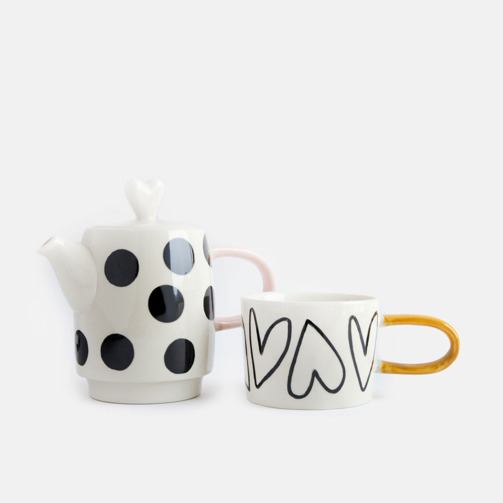 hand painted ceramic set of teapot with black dots design, pink handle and heart shaped lid and cup with heart outlines and mustard handle 