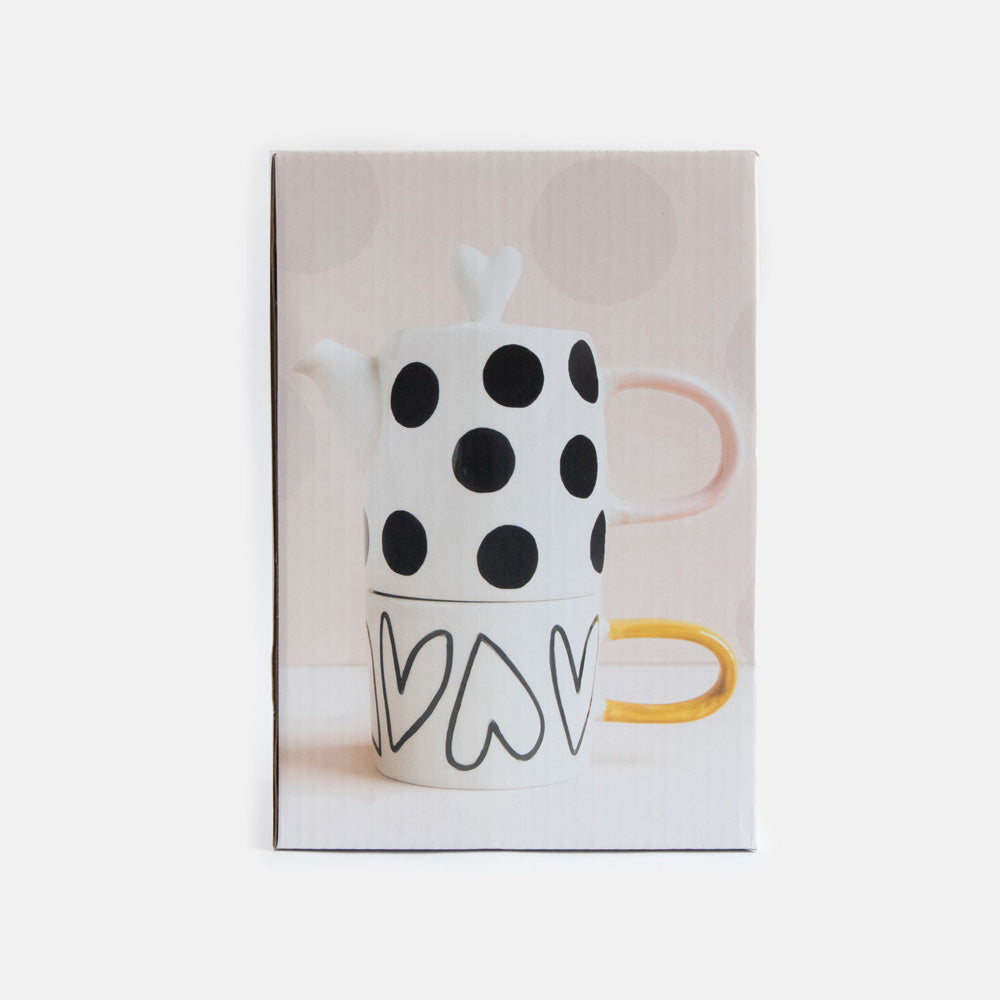 boxed up hand painted ceramic set of teapot with black dots design, pink handle and heart shaped lid and cup with heart outlines and mustard handle 