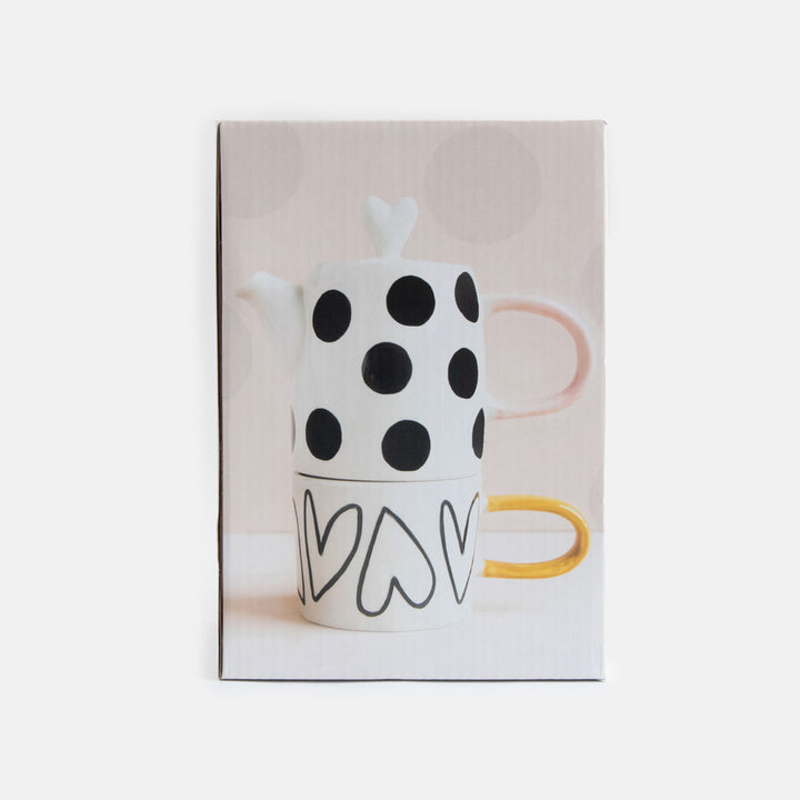 boxed up hand painted ceramic set of teapot with black dots design, pink handle and heart shaped lid and cup with heart outlines and mustard handle 