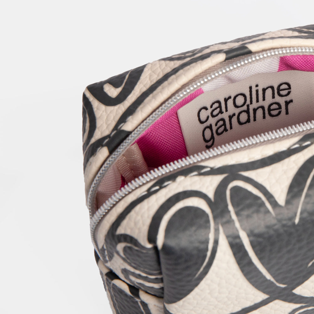 Cosmetic bag with black looped hearts pattern and pink ribbon on a white background