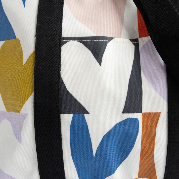 coated cotton canvas weekend bag with multicolour hearts design, black webbing grab handles and detachable shoulder strap 