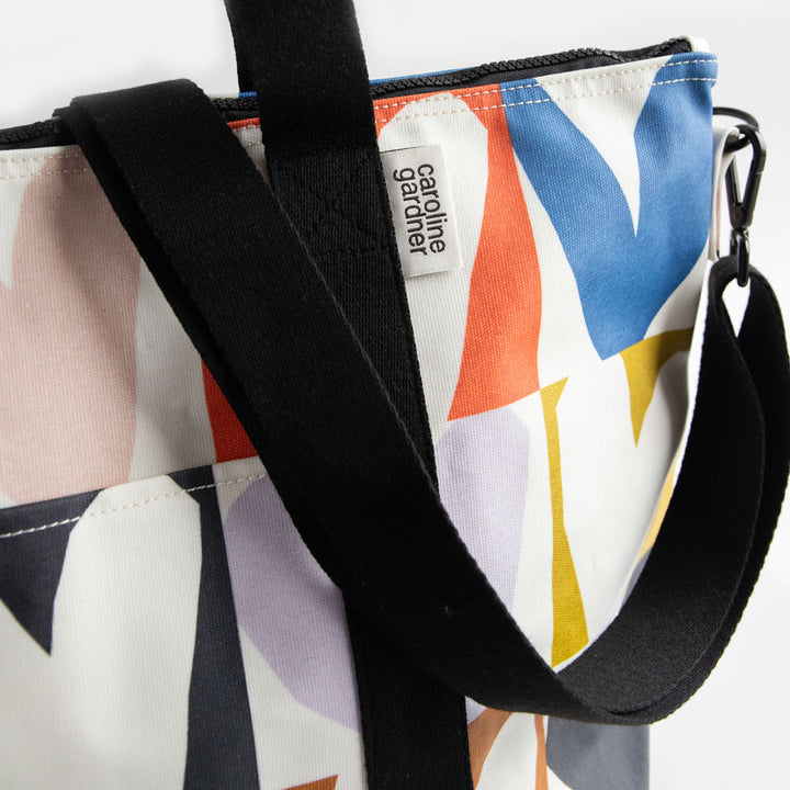 coated cotton canvas weekend bag with multicolour hearts design, black webbing grab handles and detachable shoulder strap 