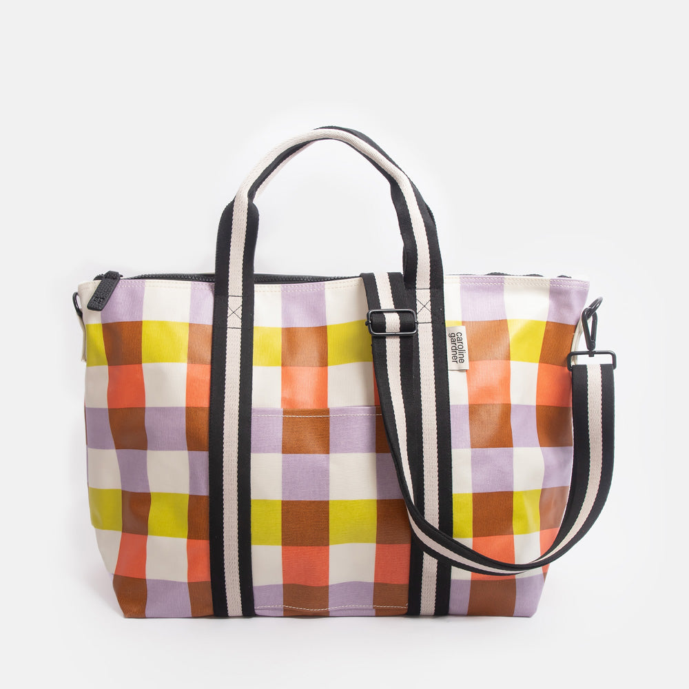 Colourful checked tote bag with black handles on a white background