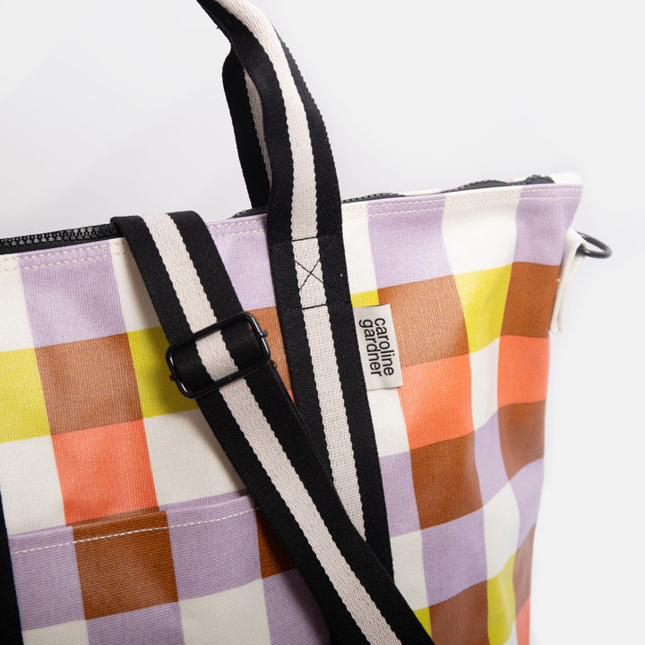 Colourful checked tote bag with black handles on a white background